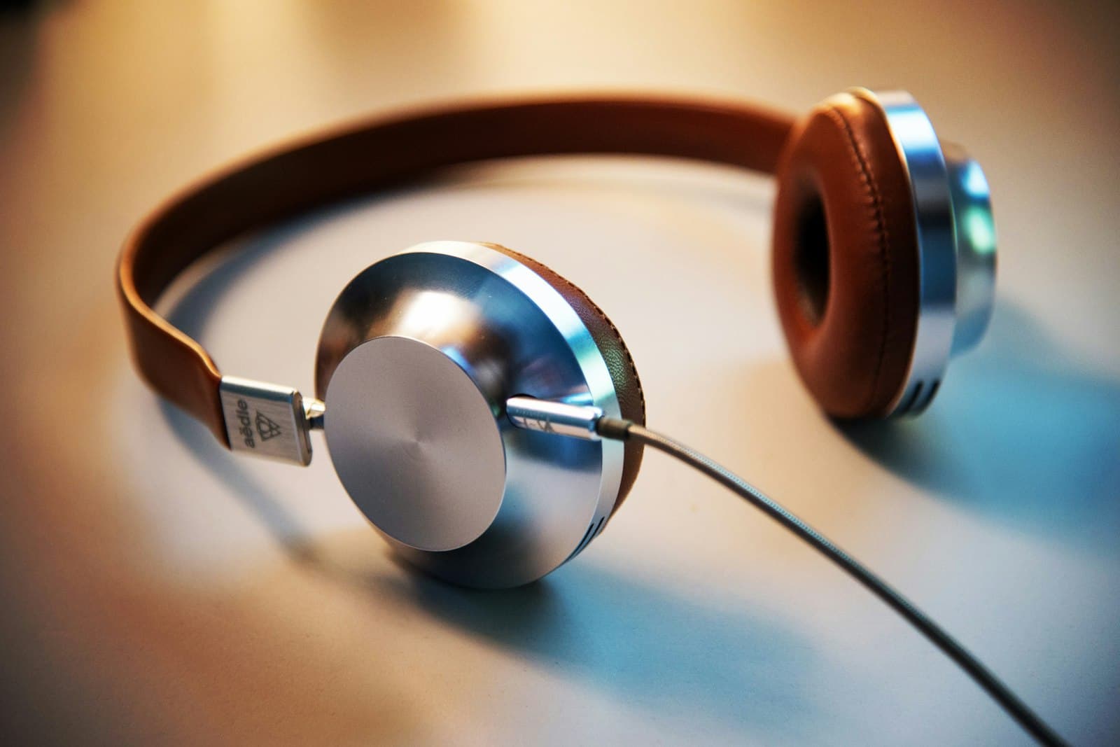 Close view of wireless earbuds resting beside a smartphone on a desk